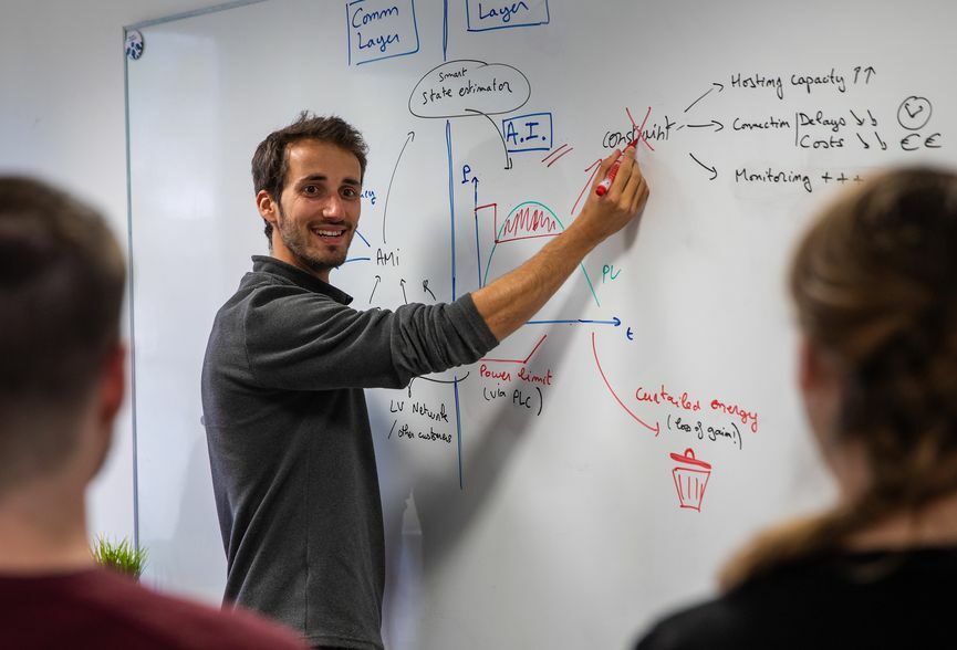 À propos de l'équipe de roseau technologie - Homme tenant un stylo pour expliquer devant un tableau