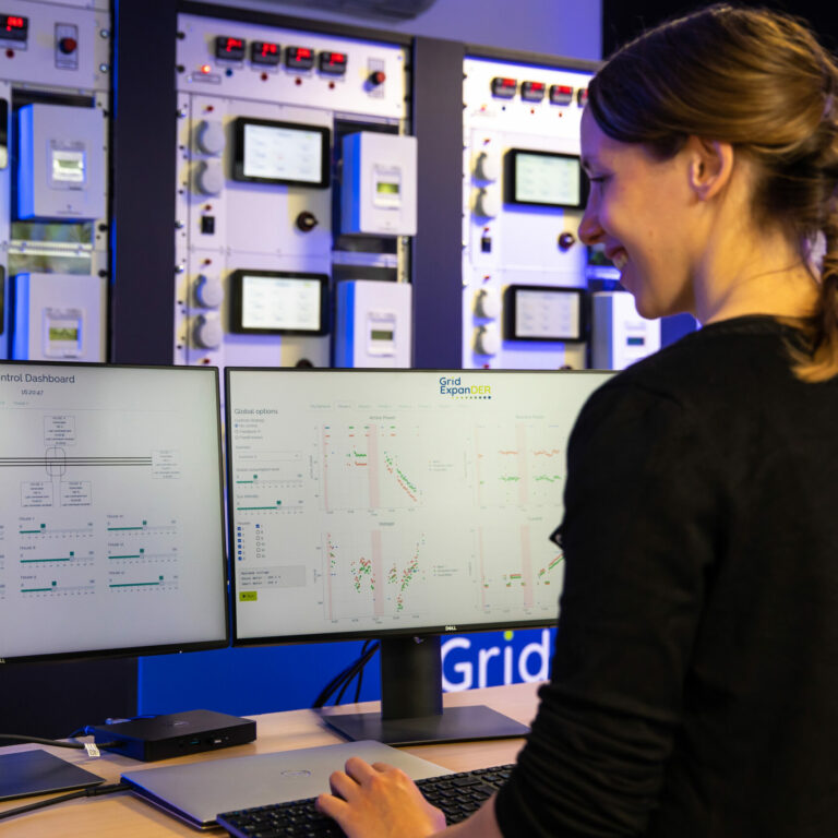 Femme utilisant Grid ExpanDER sur 2 ordinateurs pour le management des smarts grids