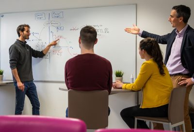 Contact Roseau Technologie - group of people in front of a white board talking about smart grid